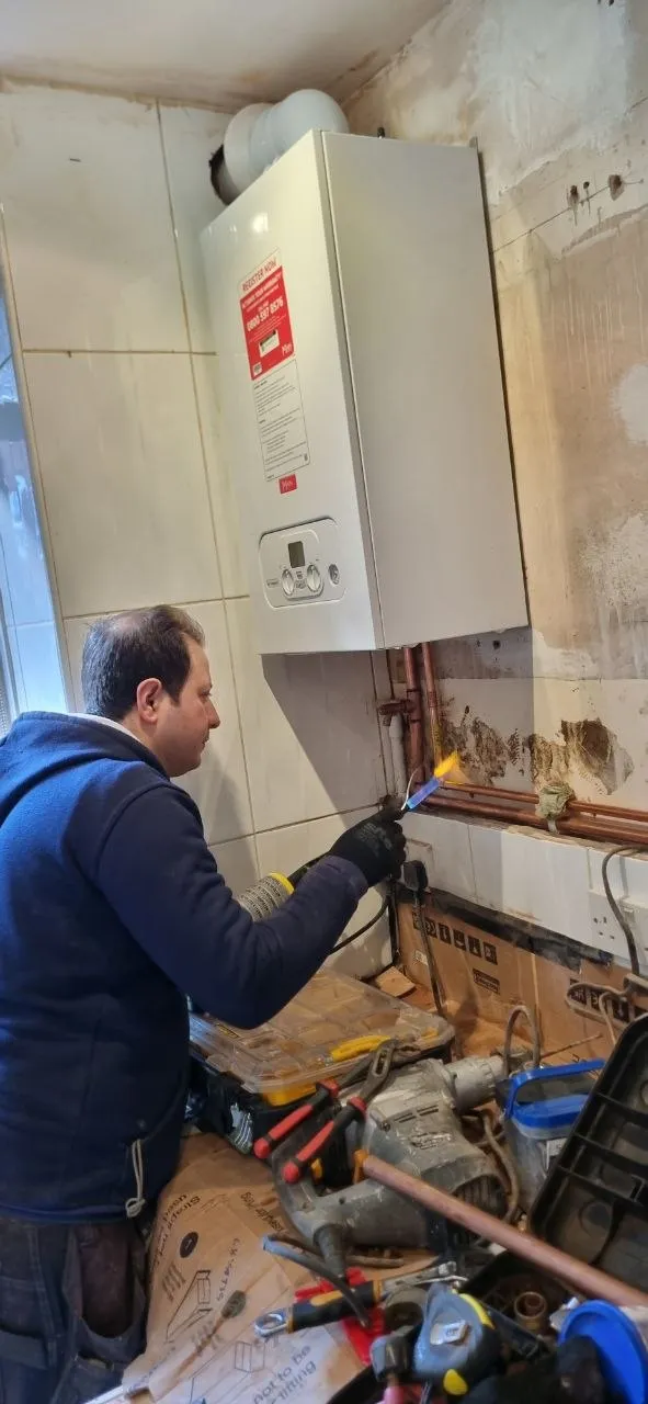 Engineer working on a boiler installation with a torch